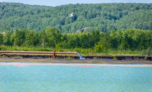 A steel pipe drains suspension fluid into a hydraulic dump as part of the process to separate effluents for reuse of water in a closed cycle. (Source: Shutterstock)
